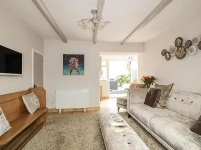 a living room with a couch and a tv at Blue Crab Cottage in St Austell