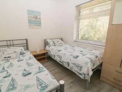 two twin beds in a bedroom with a window at Ballasalla in Liskeard