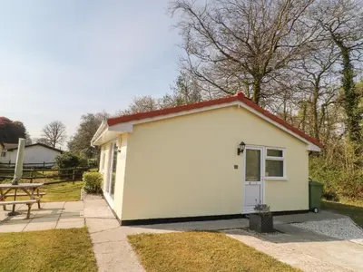 a small white shed with a picnic table at Ballasalla in Liskeard