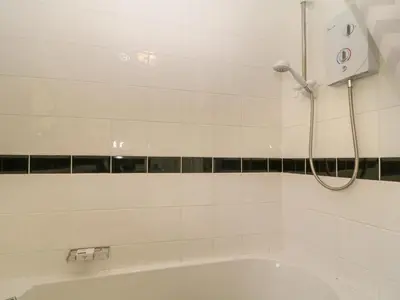 a white bathroom with a shower and a tub at Ballasalla in Liskeard