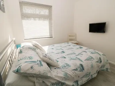a bedroom with a bed with pillows and a television at Ballasalla in Liskeard
