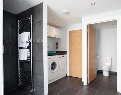 a laundry room with a washing machine and a washer at The White House in Polzeath