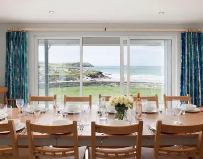 a dining room with a table and a large window at The White House in Polzeath
