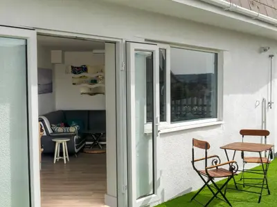 a patio with chairs and a table in front of a house at Fistral Drift in Newquay