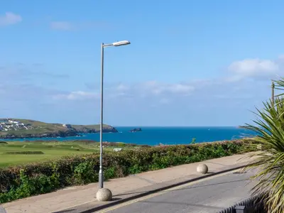 a street light on a road next to the ocean at Fistral Drift in Newquay