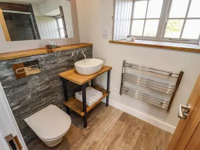a bathroom with a sink and a toilet at The Roost in Helston