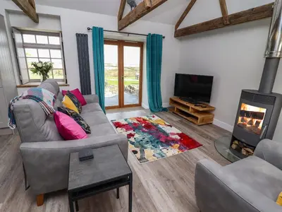 a living room with a couch and a fireplace at The Roost in Helston