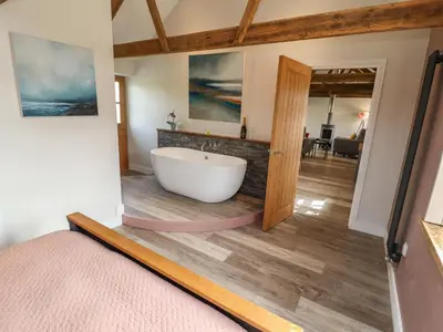 a bathroom with a large tub in a room at The Roost in Helston