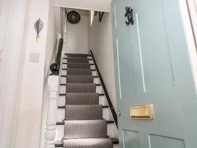 a staircase leading up to a blue door at Harbour Hideaway in Looe