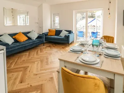 a kitchen and living room with a table and chairs at Harbour Hideaway in Looe