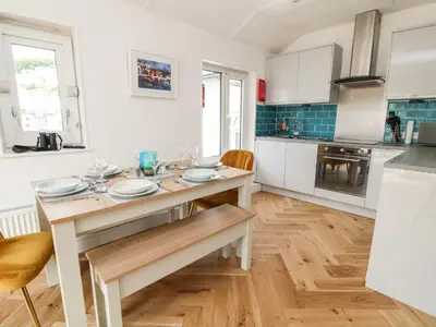 a kitchen with a table and chairs in a room at Harbour Hideaway in Looe