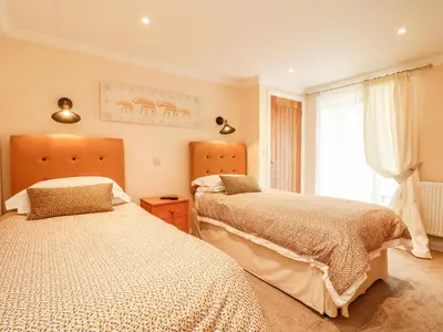 a bedroom with two beds and a window at The Old Byre in Falmouth