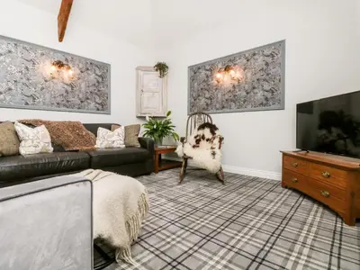 a living room with a couch and a tv at The Old Byre in Falmouth