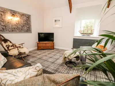 a living room with a tv and a couch at The Old Byre in Falmouth