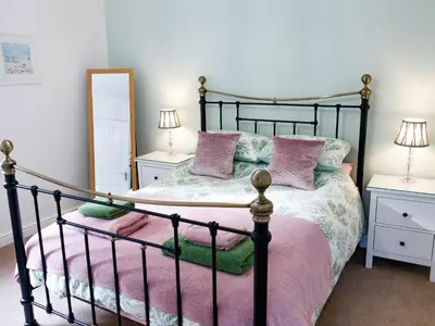 a bedroom with a black bed with pink pillows at The Old Vicarage Retreat in Bodmin