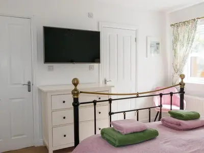 a bedroom with a bed with a tv on the wall at The Old Vicarage Retreat in Bodmin