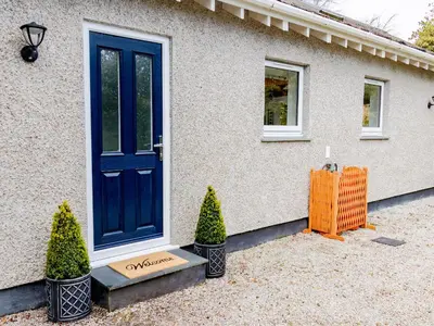 a blue door on a house with two plants at The Old Vicarage Retreat in Bodmin