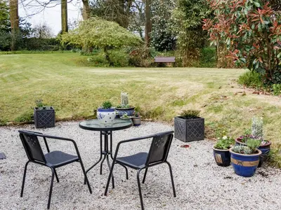 a table and two chairs and some potted plants at The Old Vicarage Retreat in Bodmin