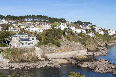 a group of houses on a hill next to a river at The Old Vicarage Retreat in Bodmin