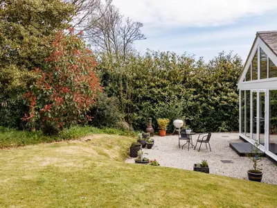 a patio with a table and chairs in a yard at The Old Vicarage Retreat in Bodmin