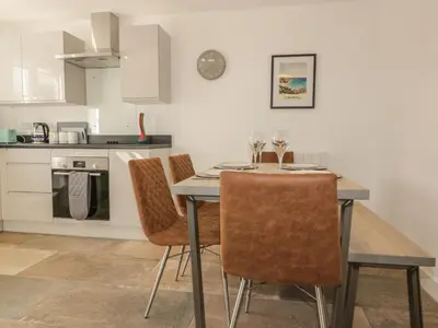 a kitchen with a dining room table and chairs at 4 Trerammet Crescent in Tintagel