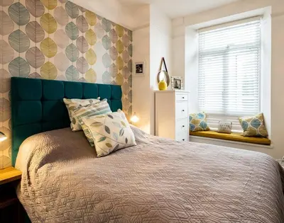 a bedroom with a large bed with a blue headboard at The View in Port Isaac