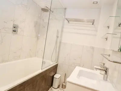 a white bathroom with a tub and a sink at 16 Arwenack Street in Falmouth