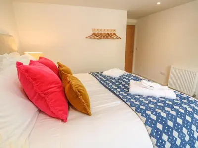 a bedroom with a bed with red and white pillows at 16 Arwenack Street in Falmouth
