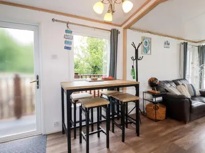 a living room with a table and a couch at Orchard View in Tintagel