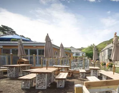 a group of picnic tables with umbrellas at Stop Tide in Port Isaac