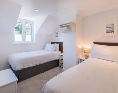 a bedroom with two beds and a window at Stop Tide in Port Isaac