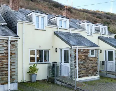 a group of white houses with a fence at Stop Tide in Port Isaac