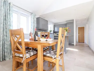 a kitchen with a wooden table and two chairs at Chy-Whel in St Austell