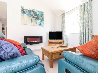 a living room with a couch and a table at Chy-Whel in St Austell