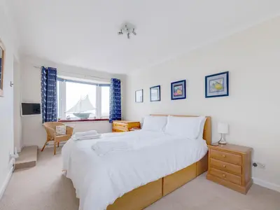 a bedroom with a large white bed and a window at Shilling Stones in Port Isaac
