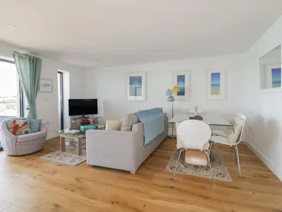 a living room with a couch and a table at Onshore in Newquay