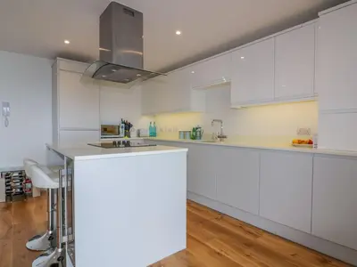 a white kitchen with white cabinets and a counter at Onshore in Newquay