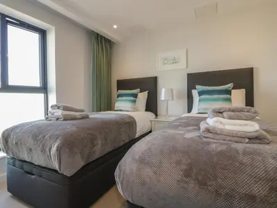 a bedroom with two beds with towels on them at Fistral Watch in Newquay