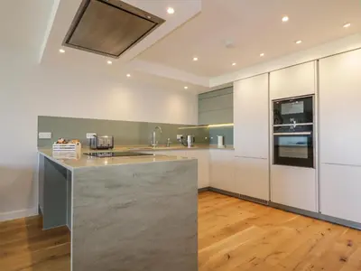 a kitchen with white cabinets and a counter top at Fistral Watch in Newquay
