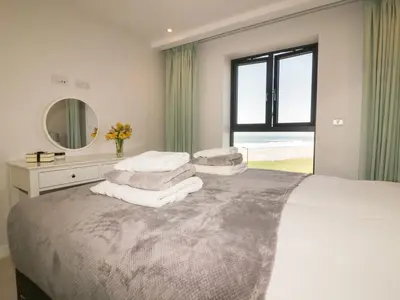 a bedroom with a large bed with towels on it at Fistral Watch in Newquay