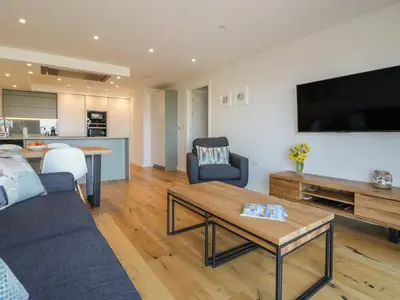 a living room with a couch and a table at Fistral Watch in Newquay