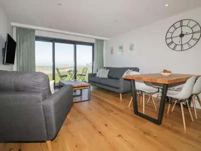 a living room with a couch and a table with chairs at Fistral Watch in Newquay