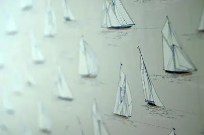 a group of miniature sailboats on a wall at The Boats in St Ives