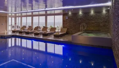 a swimming pool with chairs and a tub in a building at The Boats in St Ives