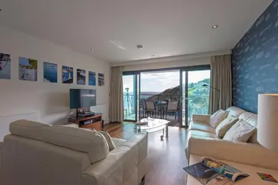 a living room with two couches and a balcony at The Boats in St Ives