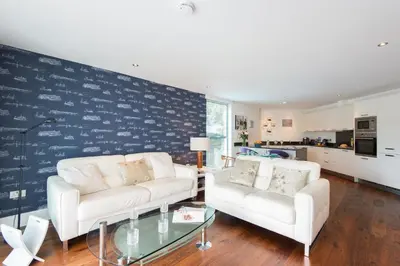 a living room with two white couches and a glass table at The Boats in St Ives