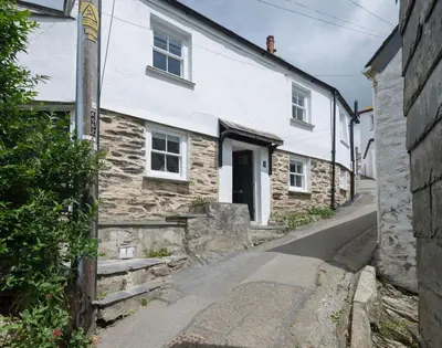 a stone house on a street in a village at Bre Cottage in Port Isaac