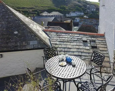 a table and chairs on a balcony with a view at Bre Cottage in Port Isaac