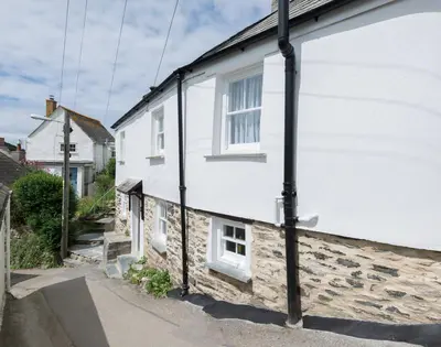a white house with white windows on a street at Bre Cottage in Port Isaac