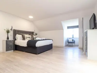 a bedroom with a large bed and a dresser in it at Penthouse 23 in Newquay